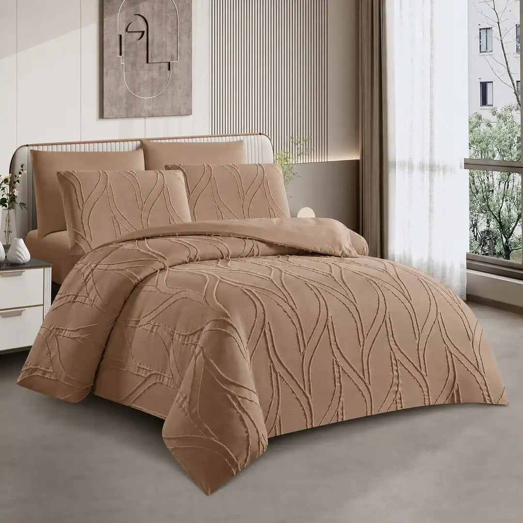 A bed dressed in a tan quilted200x200 bed sheet with matching pillows, shown in a modern bedroom setting with a window, curtains, and neutral-toned decor.