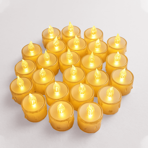 Multiple small yellow candles with glowing flames LED tea light candles with warm yellow glow