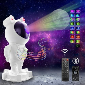 An astronaut-shaped galaxy projector emitting colorful light patterns on a wall, accompanied by a remote control and a USB cable.