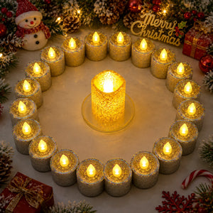 A festive arrangement of glittery silver and gold LED tea light candles in a circular ring with one larger central candle glowing in the middle, surrounded by holiday decorations including pinecones, a snowman, candy canes, and a 'Merry Christmas' sign.