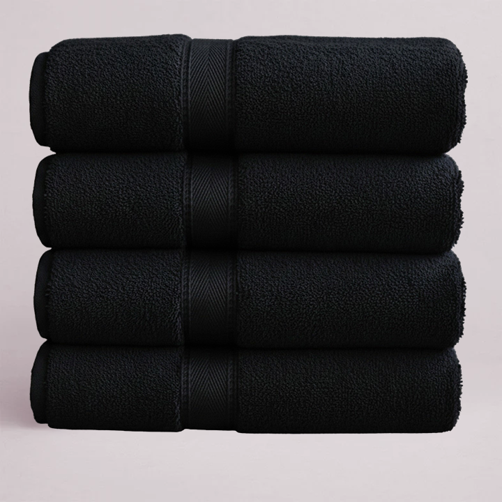 Stack of black towels on a light pink background