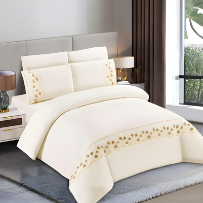 Cream bedding set with gold embroidered trim including bedsheet, duvet cover, fitted sheet, and pillowcases