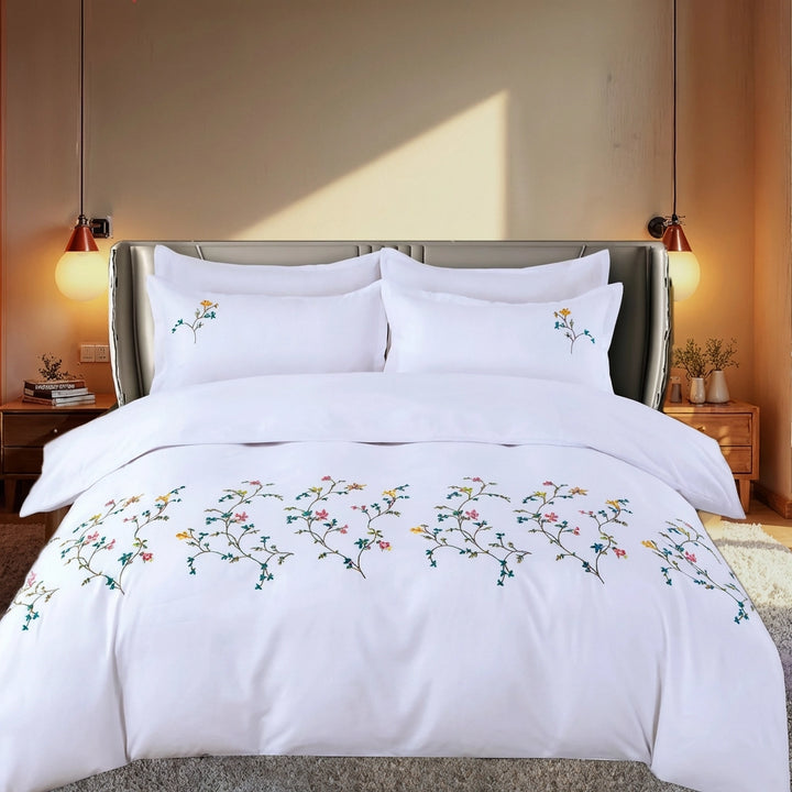 White duvet cover with embroidered floral vine pattern on neatly made bed
