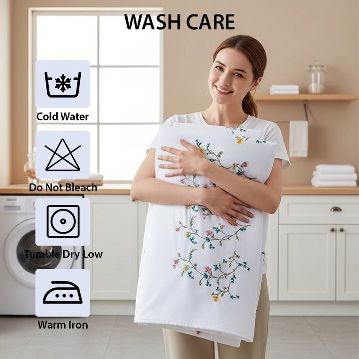 White duvet cover embroidered with small flowers, styled with matching pillows