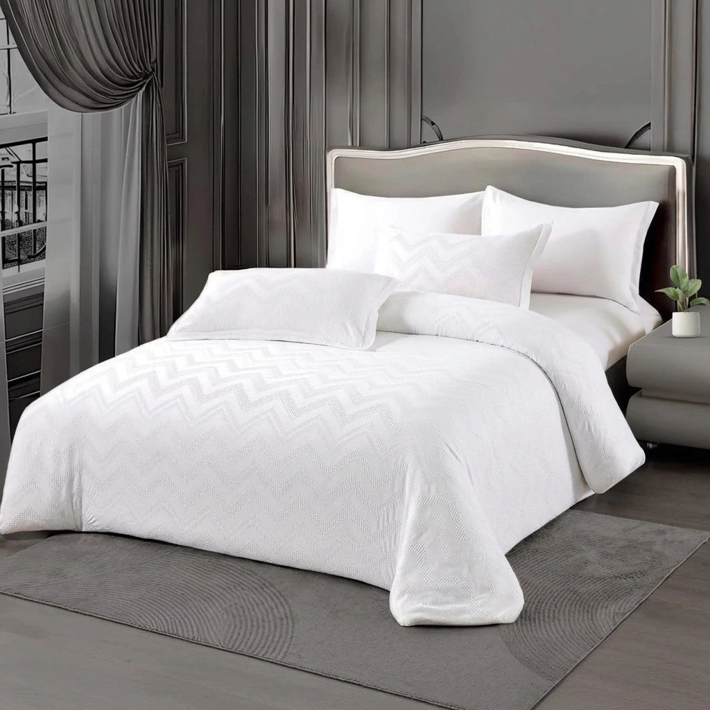 White king size bed sheet set dressed with zigzag textured quilt and matching pillow