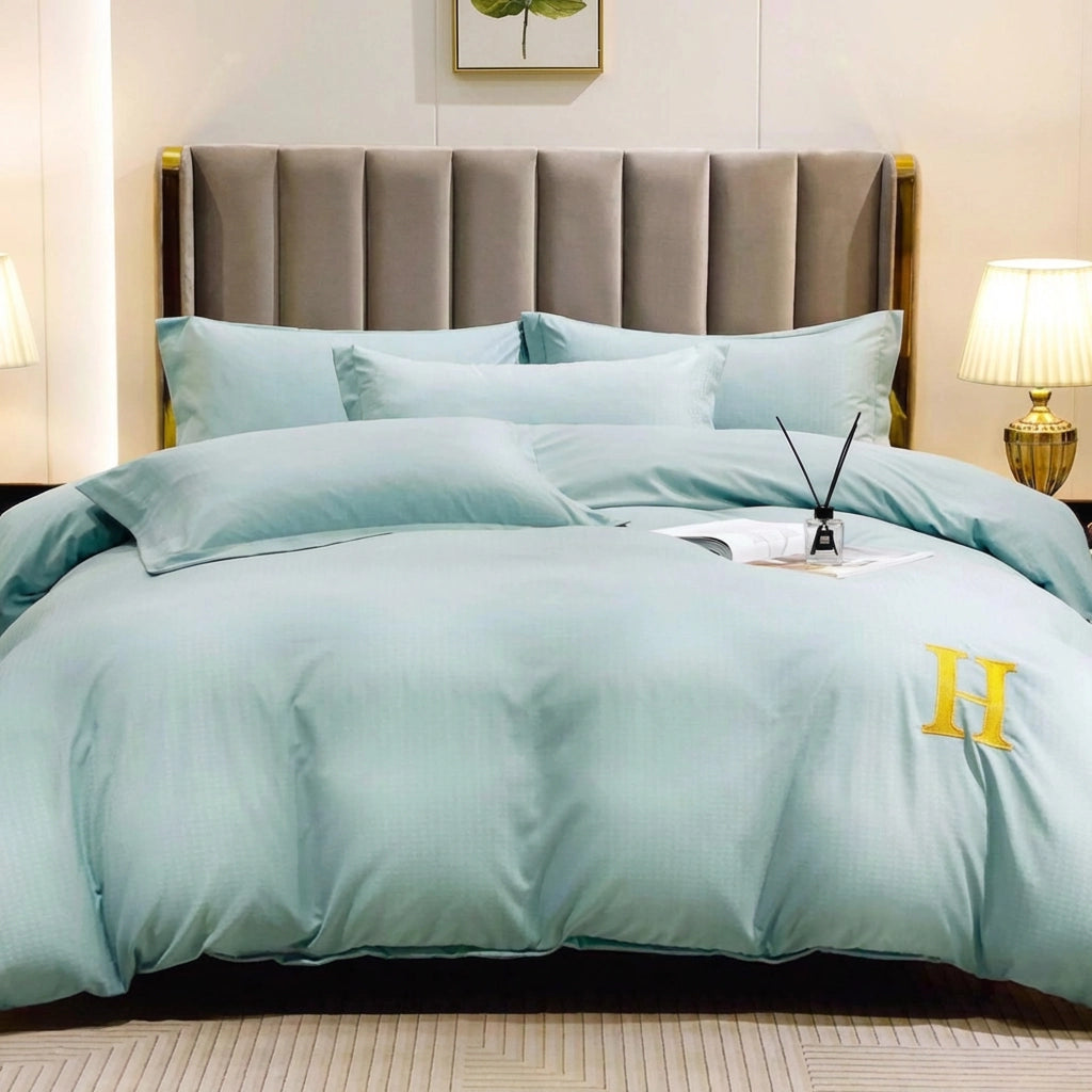 Mint green bed sheet styled with quilt cover and pillow cover on upholstered bed