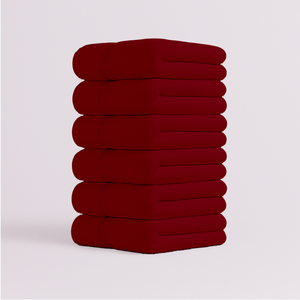 Stack of deep red bath towels with soft plush texture