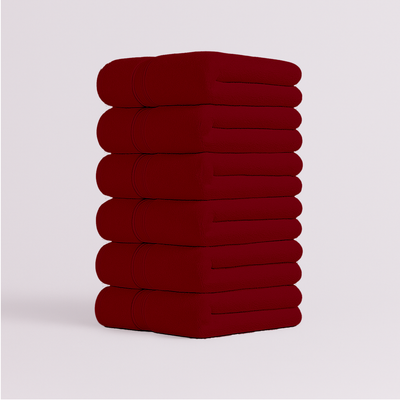 Stack of deep red bath towels with soft plush texture