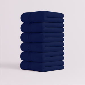 Stack of navy blue bath towels folded neatly