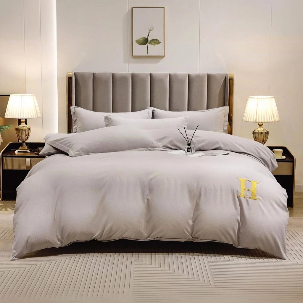 Light grey bed sheet styled with quilt cover and pillow cover on upholstered bed