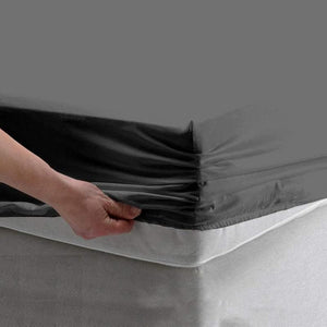 Grey fitted bed sheet stretched neatly over mattress