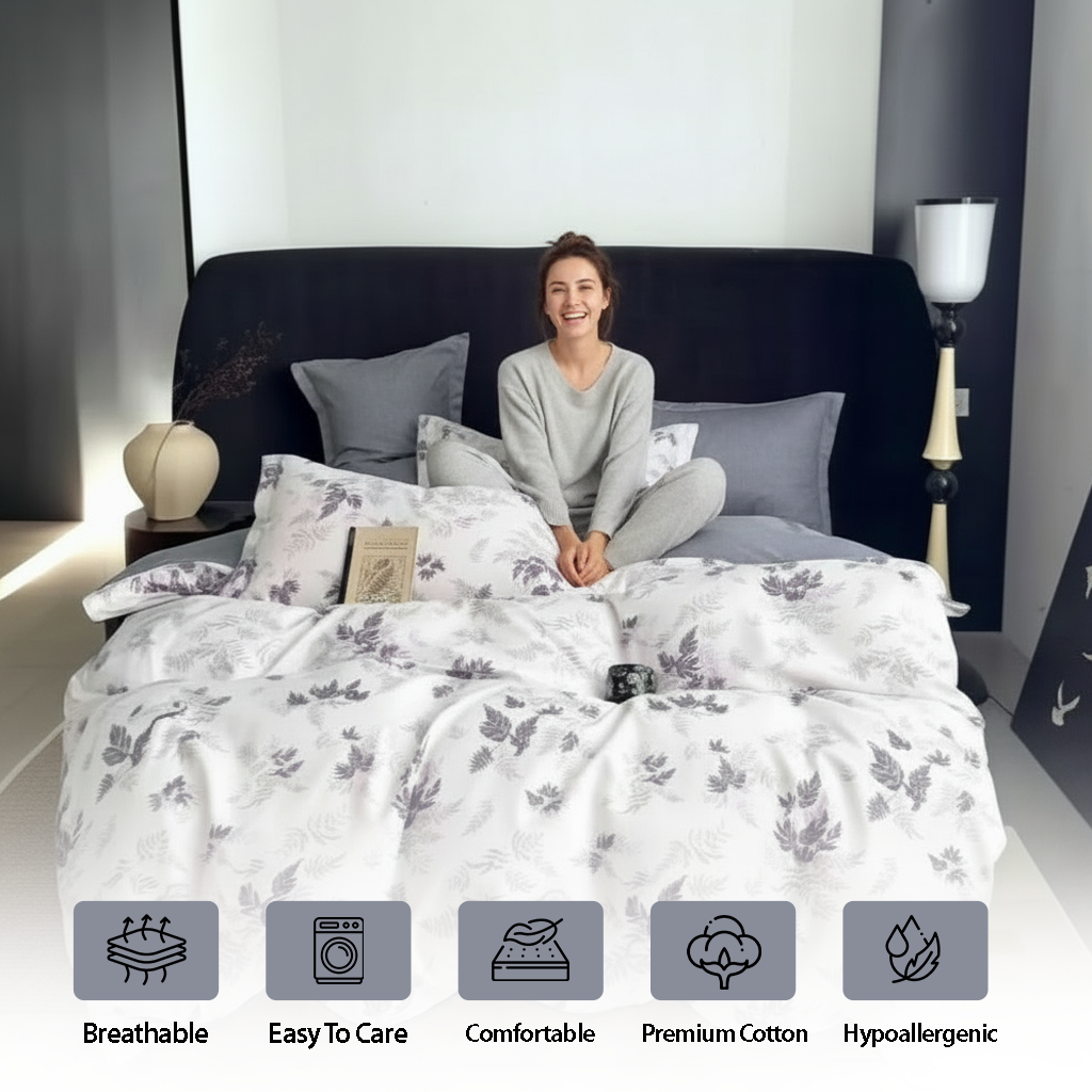 Botanical print quilt arranged with charcoal cushions and pillows