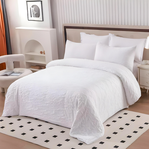 White bedding set with quilt cover, fitted sheet, and pillow covers on bed