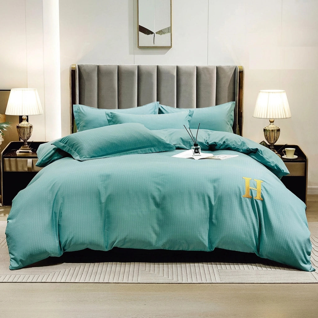 Teal green bed sheet arranged with quilt cover and pillow cover on modern bed