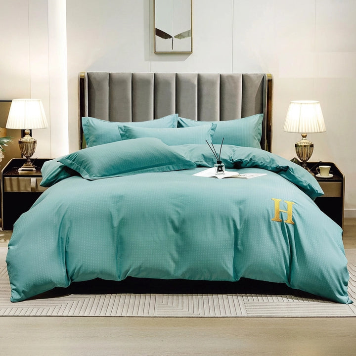 Teal green bed sheet arranged with quilt cover and pillow cover on modern bed