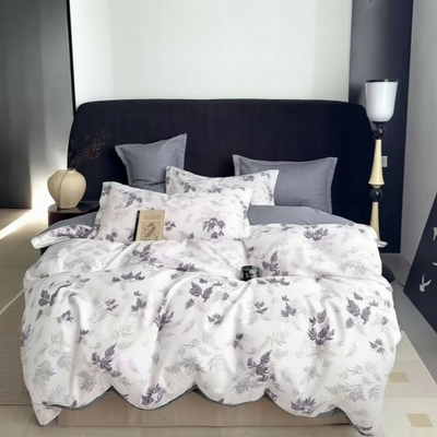 White bedding featuring soft grey leaf patterns layered across the bed