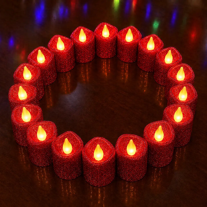 A circular arrangement of twenty red glittery flameless LED taper candles with glowing yellow-orange faux flames, set on a dark reflective surface.