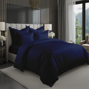 Navy blue bedding set with striped duvet cover, fitted sheet, and pillowcase