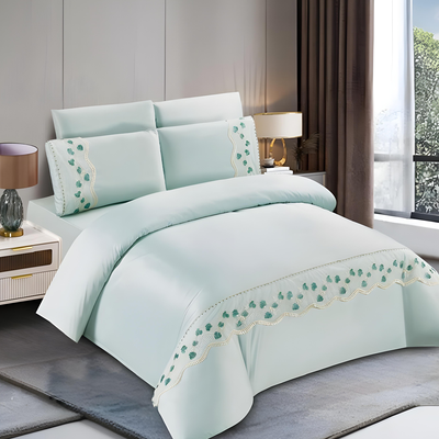 Mint green bedding set with embroidered trim including bedsheet, duvet cover, fitted sheet, and pillowcases