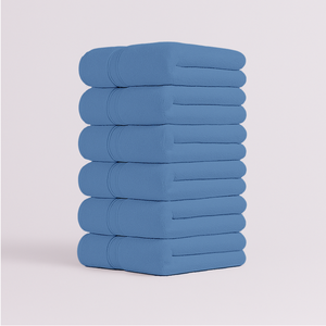 Stack of blue towels set  on a light gray background in uae