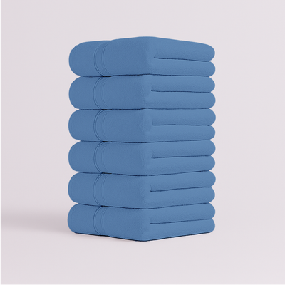 Stack of blue towels set  on a light gray background in uae