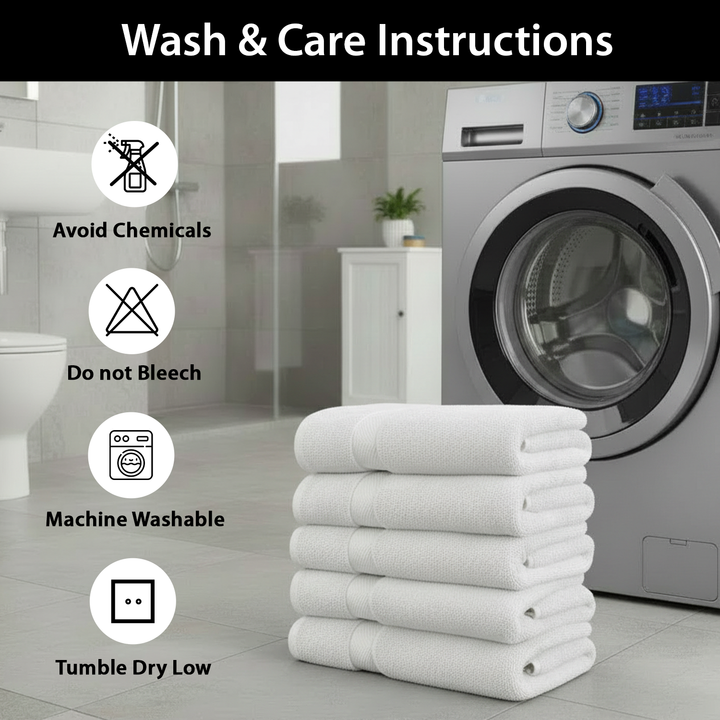 Stack of white spa towels with wash care instructions in front of a washing machine.