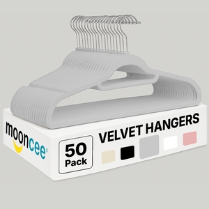 velvet clothes hangers with metal hooks stacked together on a neutral background