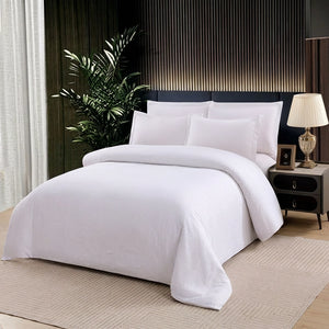 White bedding set with quilt cover, bed sheet, and pillow covers on modern bed