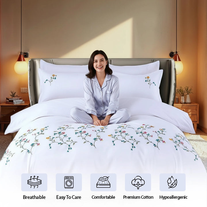 White bedding set featuring colorful embroidered floral design across duvet