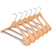 Set of natural wooden clothes hangers with curved shoulders and metal hooks